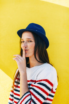 Portrait of young woman doing keep quiet sign.