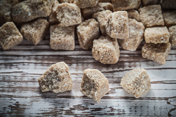 Heap of vintage cane sugar cubes on wooden board
