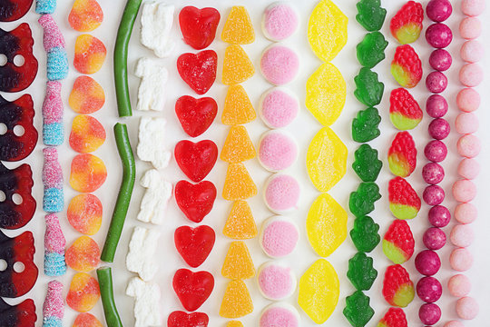 Plenty of colourful gummy candies in lines seen from above