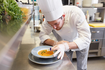 happy male chef cooking food at restaurant kitchen