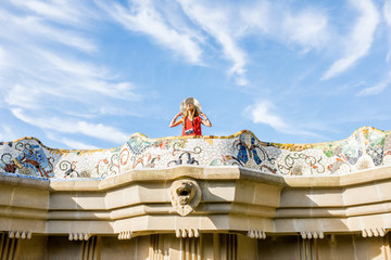 View on the beautiful terrace decorated with mosaic with happy woman tourist in Guell park in...