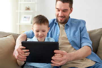 father and son with tablet pc playing at home