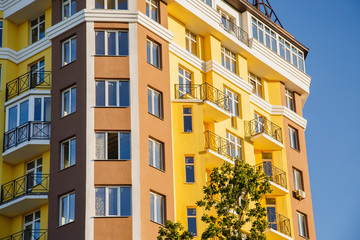 Details of new constructed colorful multi-story building. Modern residential construction. Residential fund. Building of he city. New yellow house