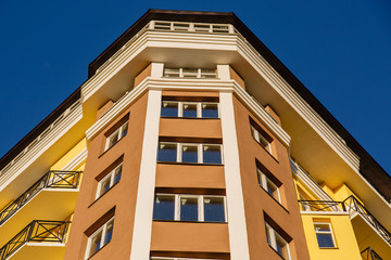 Details of new constructed colorful multi-story building. Modern residential construction. Residential fund. Building of he city. New yellow house