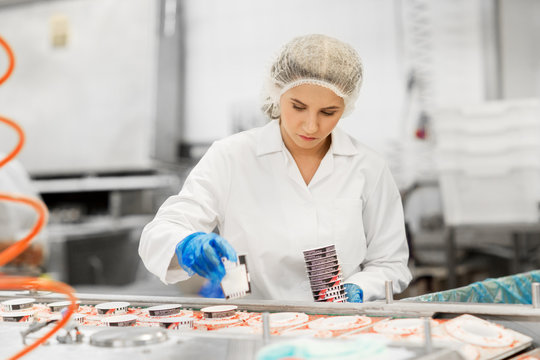 woman working at ice cream factory conveyor