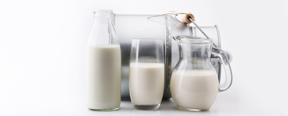 A jug of milk and glass of milk on white background.