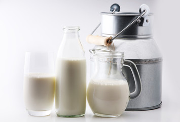 A jug of milk and glass of milk on white background.