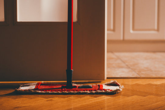 Red mop in the room on clean parquet