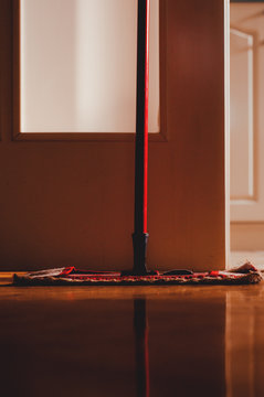 Red mop in the room on clean parquet