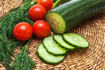 tomatoes and sliced cucumber with dill on a wooden board
