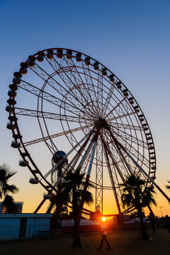 Ferris wheel on amazing sunset sky background