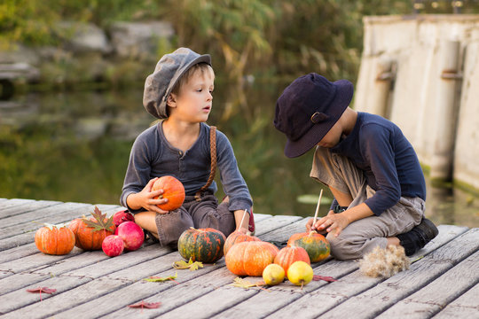 Children paint small Halloween pumpkins