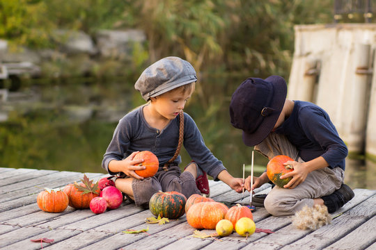 Happy children paint small Halloween pumpkins