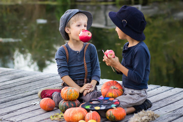 Fototapeta premium Nice boys sitting with pumpkins and apples