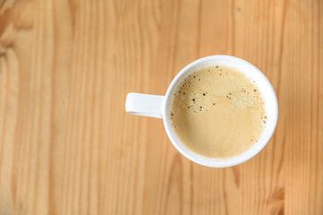 Weiße Kaffeetasse mit Kaffee auf einem Holztisch mit Textfreiraum - Flat Lay