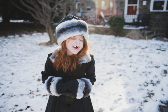 Little girl laughing in dress coat