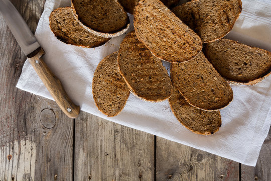 Toasts and knife on wooden table