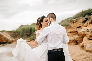 Obraz premium young couple groom with the bride on a sandy beach