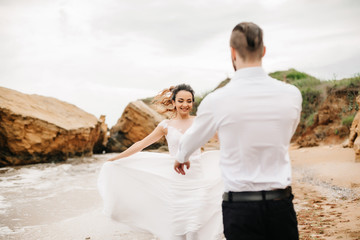 Obraz premium young couple groom with the bride on a sandy beach