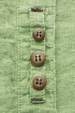 Three replacement buttons sewn on the inside of a shirt bracket.