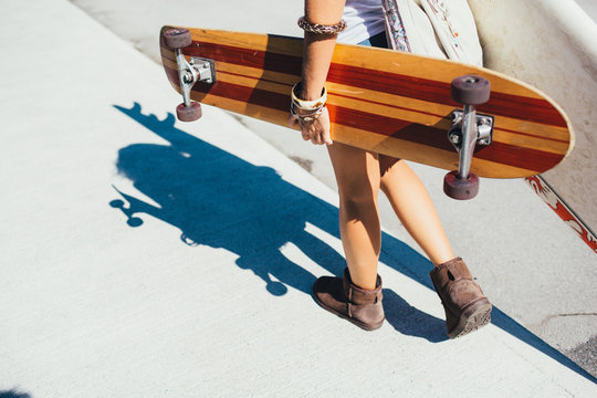 Woman walking with her surfboard and longboard