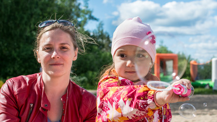 Little girl with mom let the air bubbles.