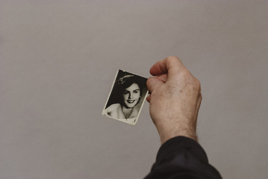 Senior Man Holding 50 Year Old Photo of His Wife