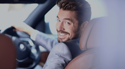 Portrait of an handsome smiling business man driving his car