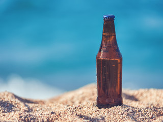 Bottle of beer on the beach sand against the sea. - 177182911