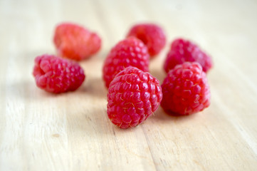 Ripe sweet raspberries on wooden table, isolated