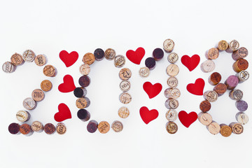 Inscription 2018 laid out the wine corks on white background with red hearts shape 