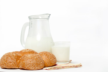 Glass jug, glass Cup and bread on a napkin on white background