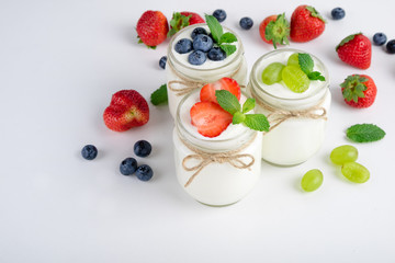 Fresh yogurt with berries in glass jars. Dairy products. Healthy food, dieting and breakfast concept. Copy space