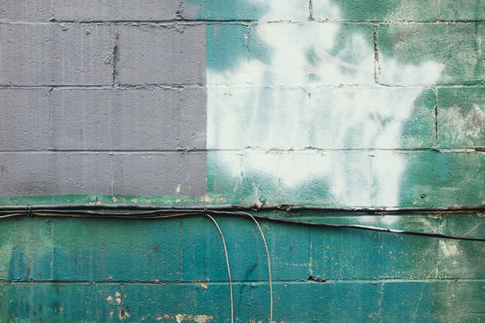 Colorful paint covering graffiti tags on building wall