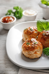 Plate with delicious meatballs on table