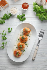 Plate with delicious meatballs and sauces on wooden table