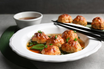 Delicious meatballs with sauce in plate on table