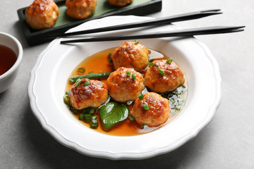 Delicious meatballs with sauce in plate on table