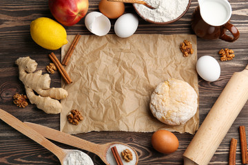 Parchment paper, raw dough and ingredients on kitchen table