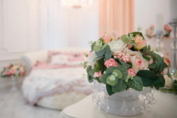 Artificial flowers. Vase with a flower arrangement in an expensive interior.