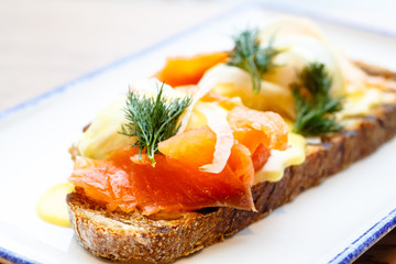 Sandwich with salmon and poached egg, the yolk flows beautifully.