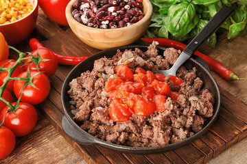 Cooked minced meat, sauce and vegetables on kitchen table