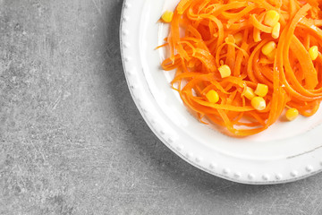 Plate with raw carrot spaghetti on table