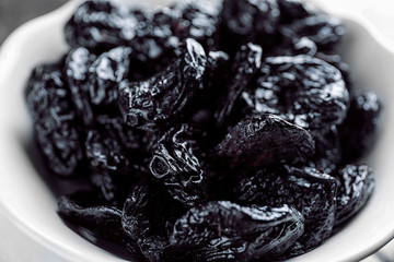 Bowl with tasty dried plums, closeup