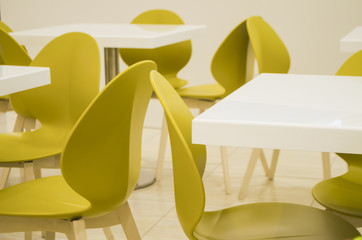 White tables and yellow chairs in empty cafe
