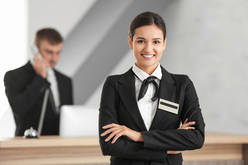 Female hotel receptionist at workplace - obrazy, fototapety, plakaty