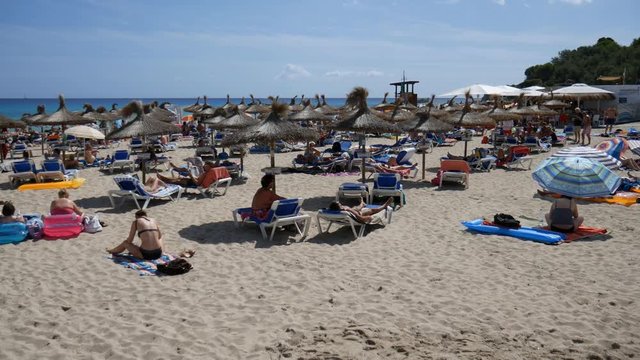 Cala Ratjada Mallorca Spain: Tourists sunbathing on the Son Moll beach