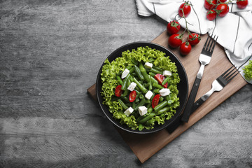 Bowl with delicious green beans salad on wooden table