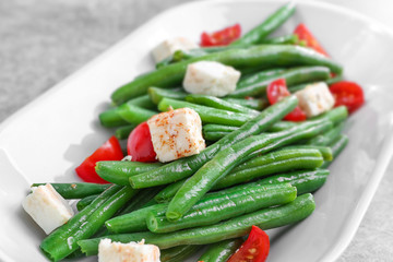 Plate with delicious green beans salad on table, closeup