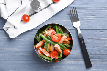 Bowl with delicious green beans salad on wooden table